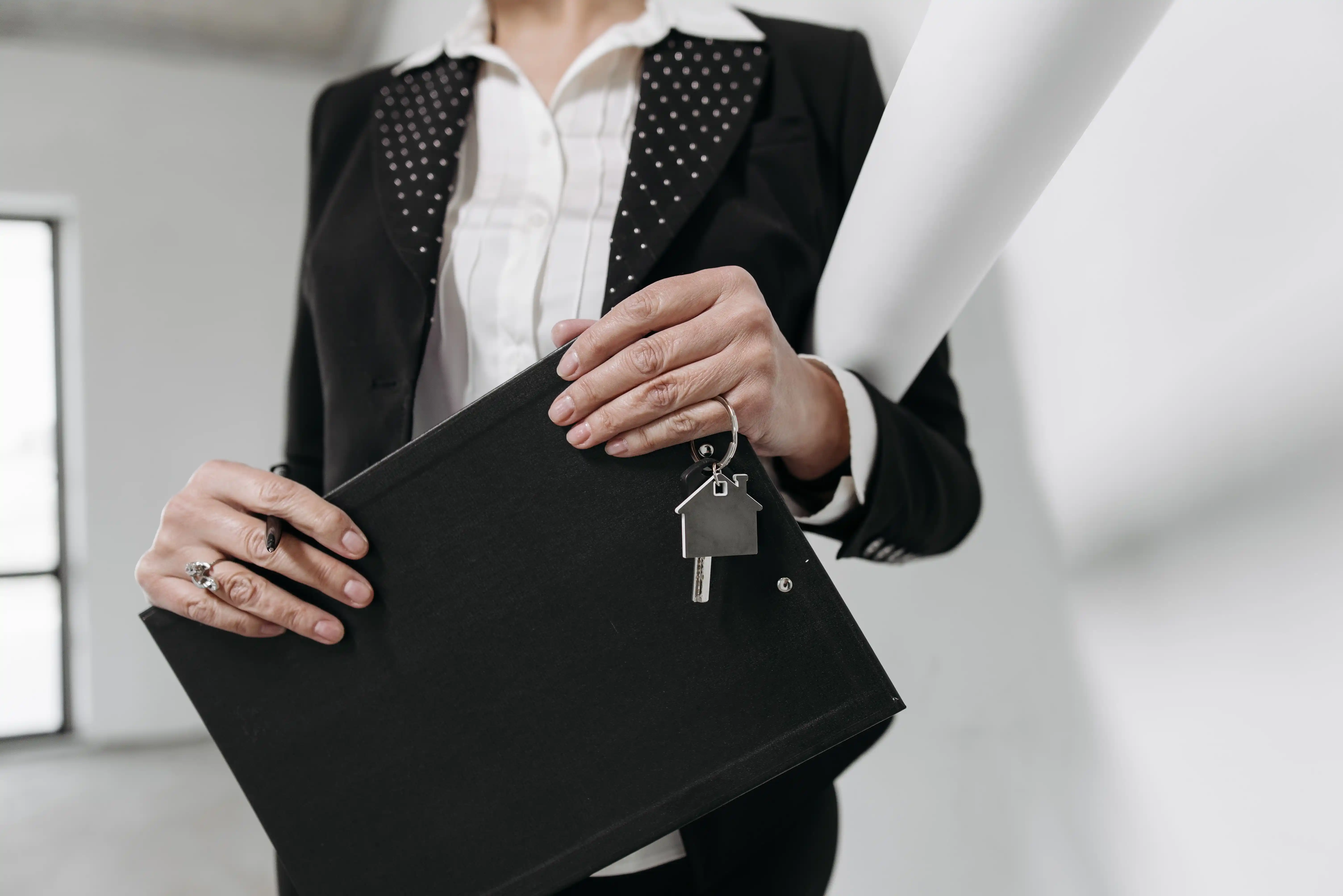 Courtière professionnelle tenant un dossier et des clés de propriété