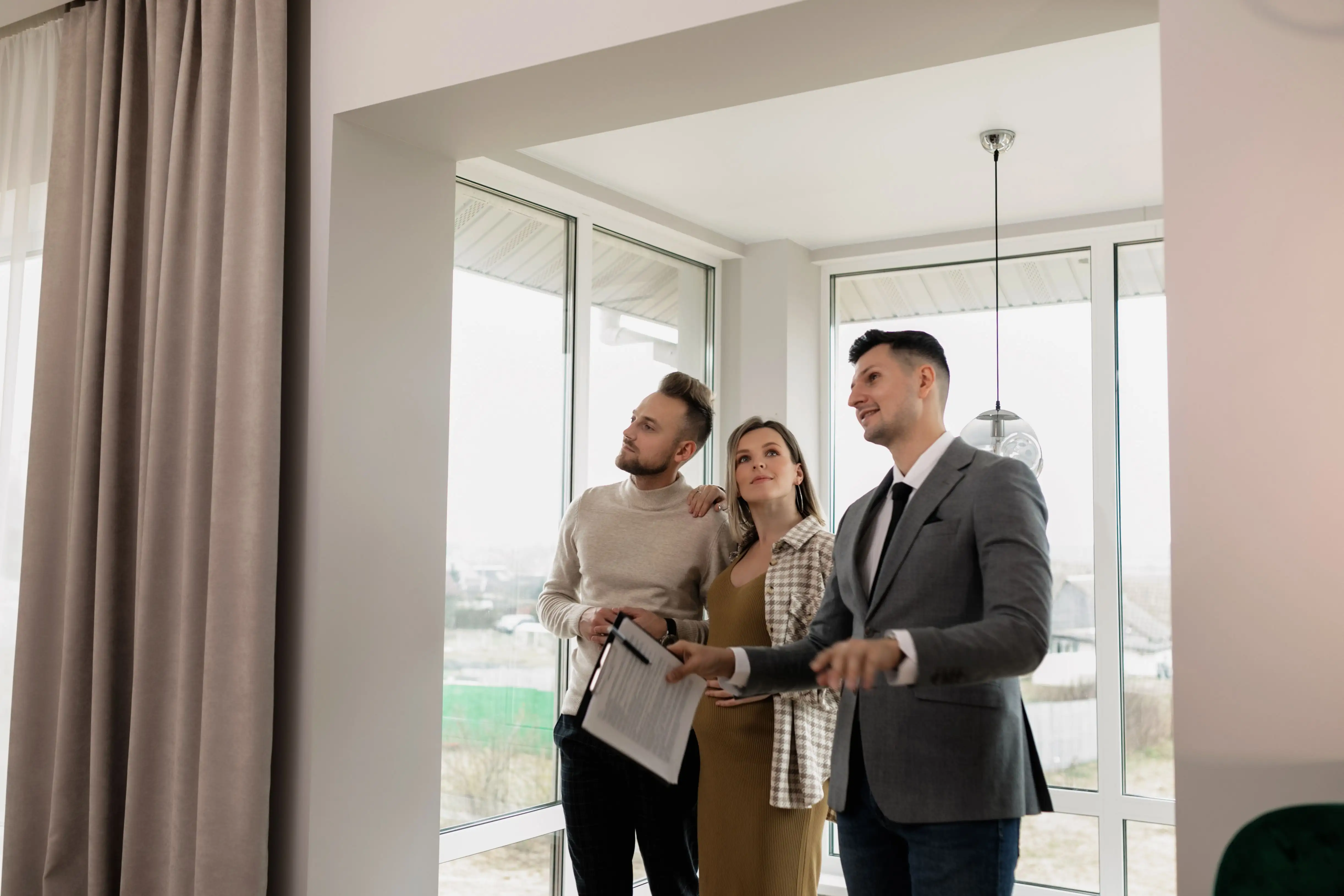 Courtier faisant visiter une propriété lumineuse à un jeune couple